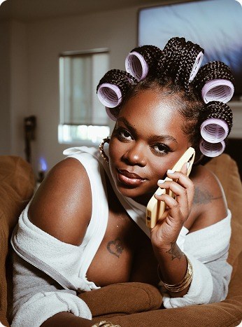 Model with curlers on the phone wearing a CHOC robe